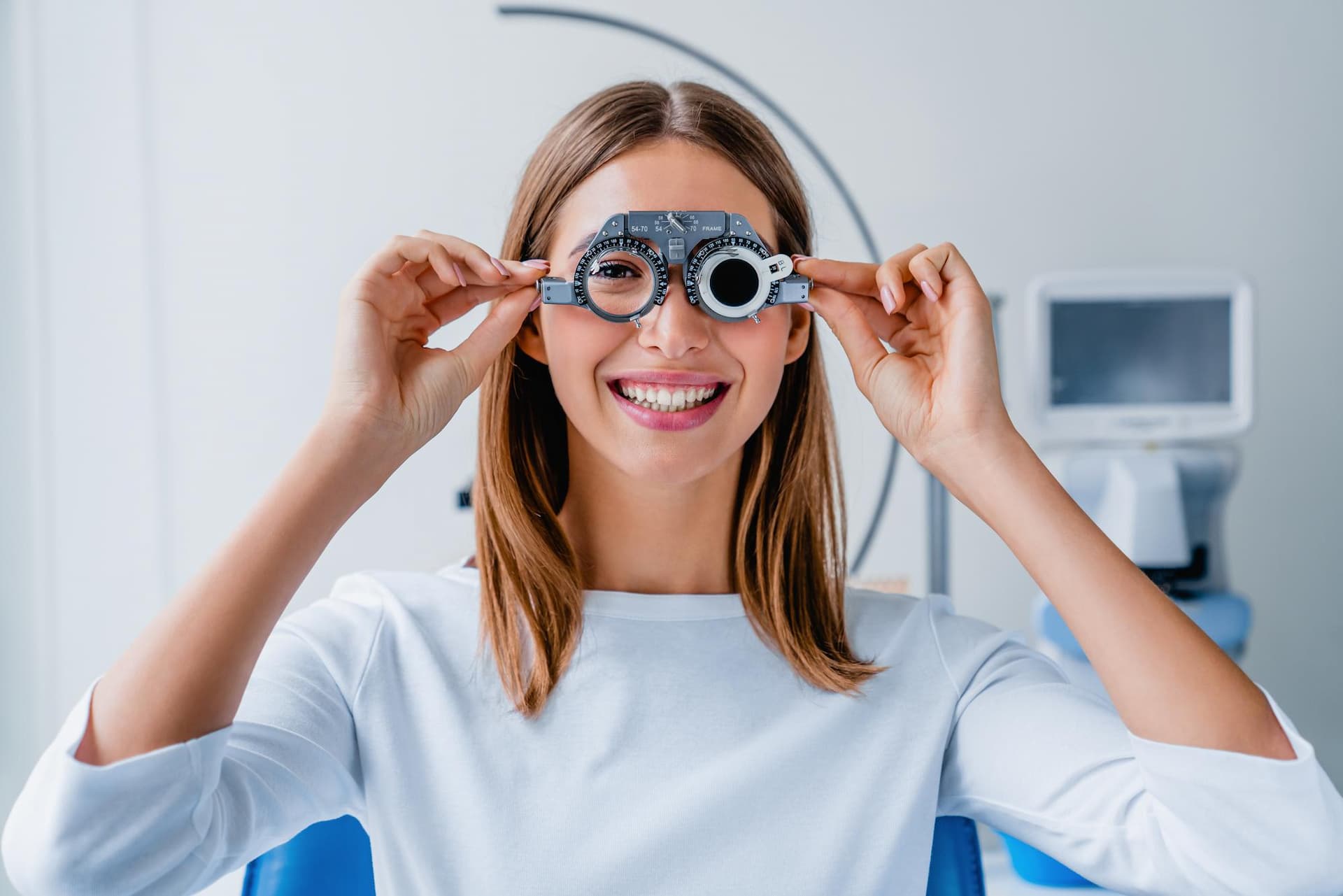 young woman checking vision with eye test glasses during a medical examination at the ophthalmological office